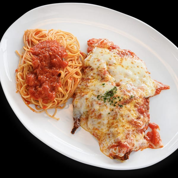 Chicken Parmigiana with melted mozzarella and spaghetti with marinara sauce on a white plate.