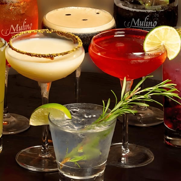 A variety of il Mulino cocktails, including a red martini, a creamy drink, and a clear drink with rosemary.