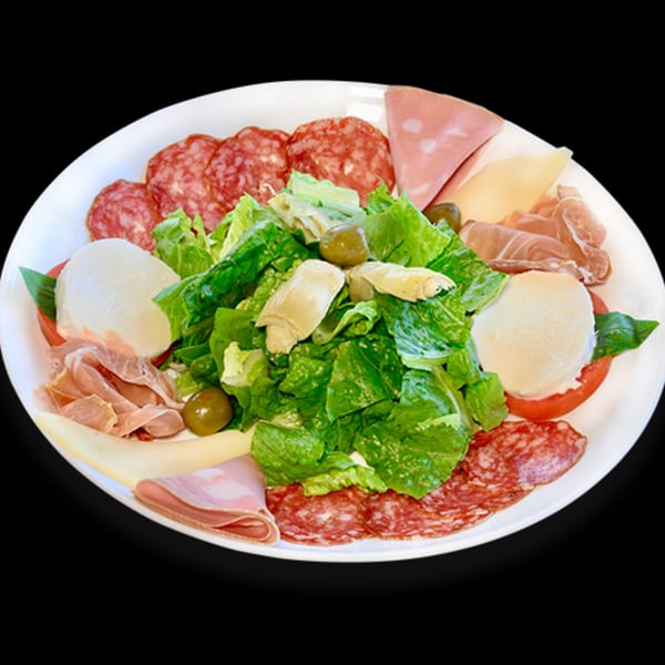 A large antipasto platter with various cured meats, cheeses, fresh mozzarella, salad, and olives.